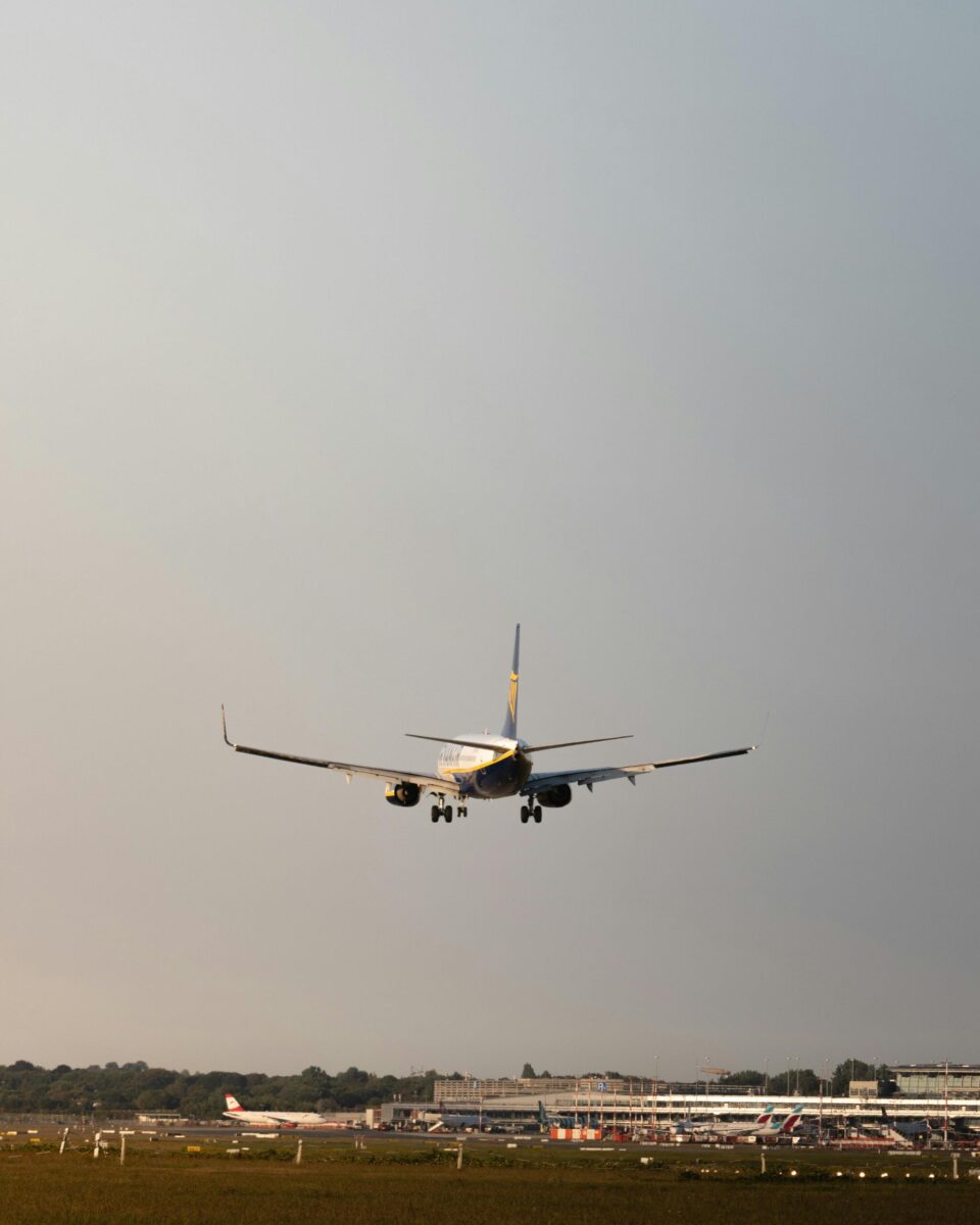 A commercial airplane approaches landing at sunset, showcasing aviation at Hamburg Airport.
