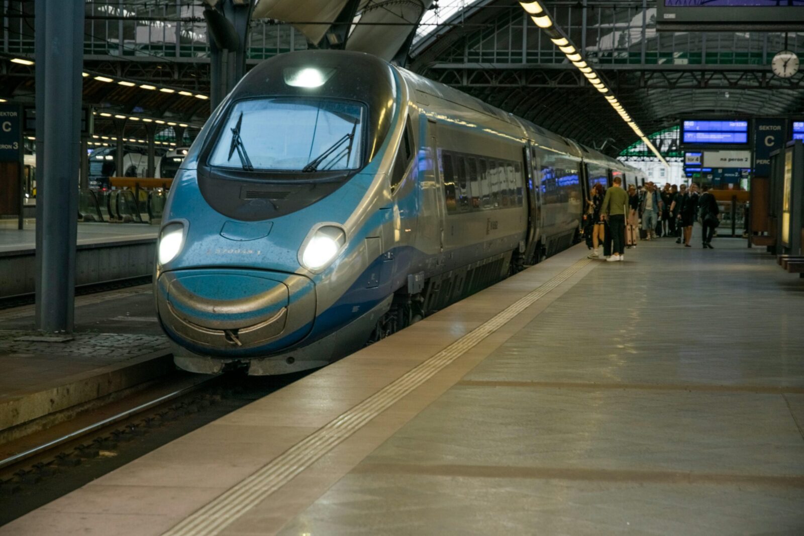 High-speed train arriving at Wrocław's bustling station platform.