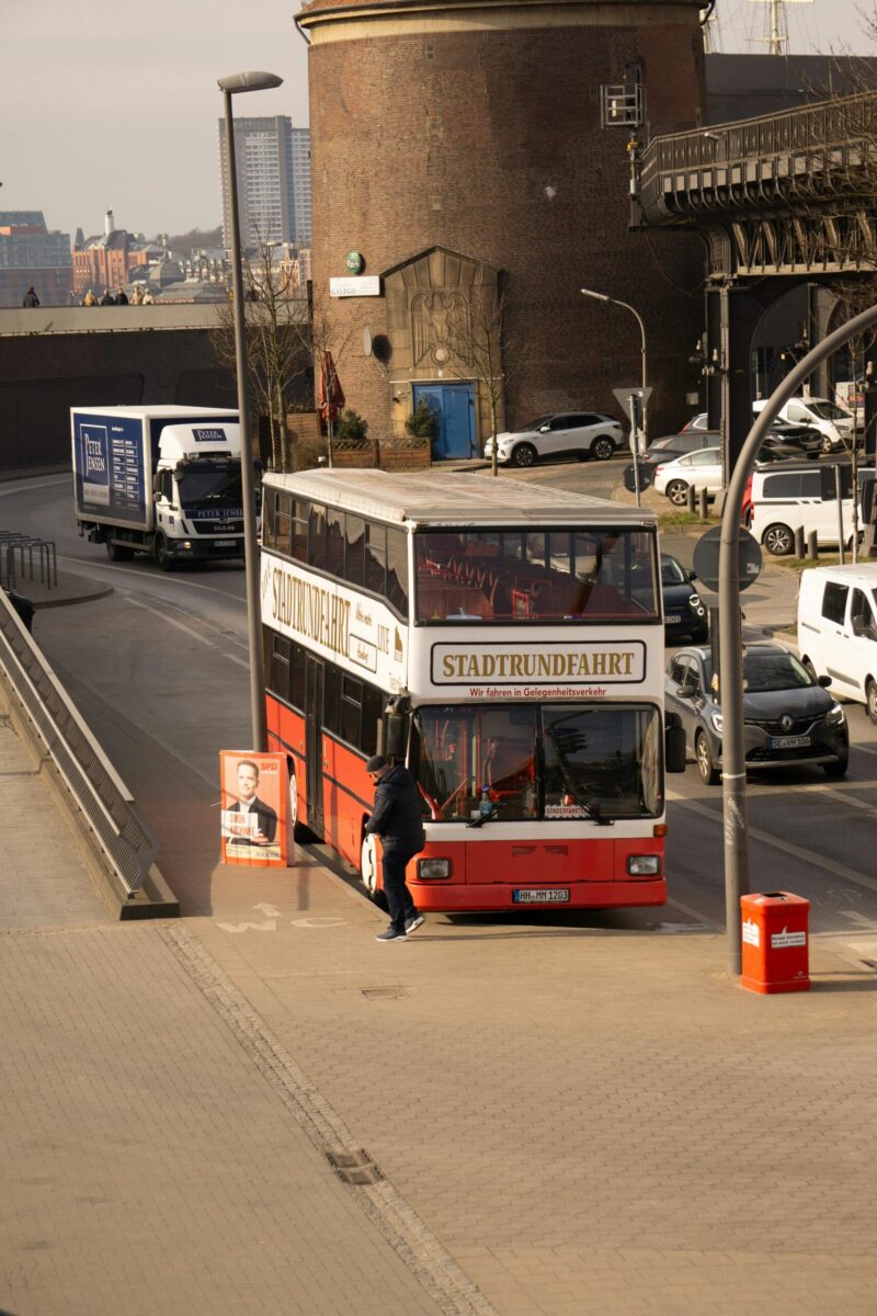 Tourist double-decker bus in Hamburg city center, showcasing urban architecture.